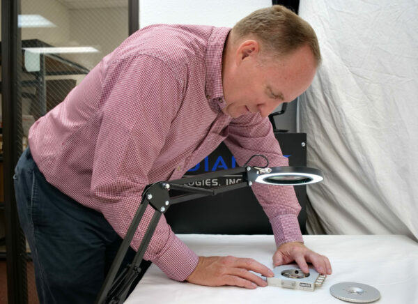 Michael McDaniel examining a sample on the Linkam Probe Stage through a magnifying light